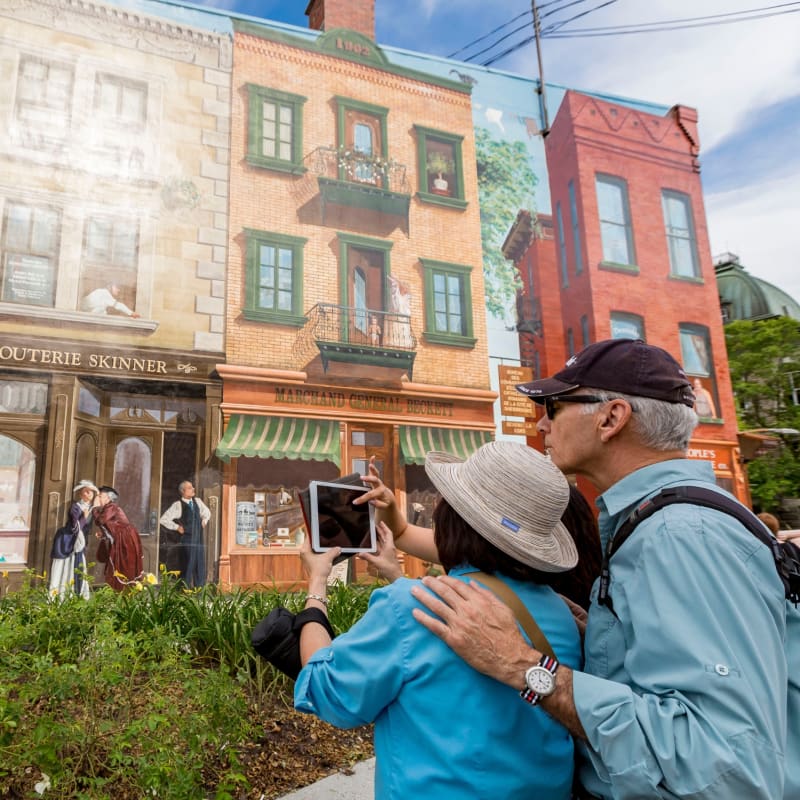 Couple taking a picture of a mural in Sherbrooke.