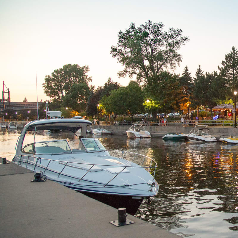 Waterfront with brightly lit shops and docked boats.