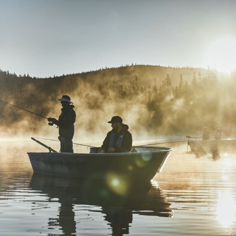 Two people in a fishing boat at sunrise