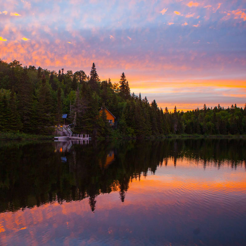 Cottage by a lake at sunset