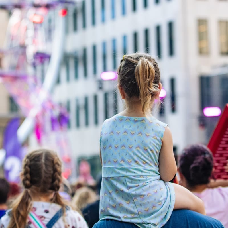 A child perched on shoulders, taking in the scene above the crowd