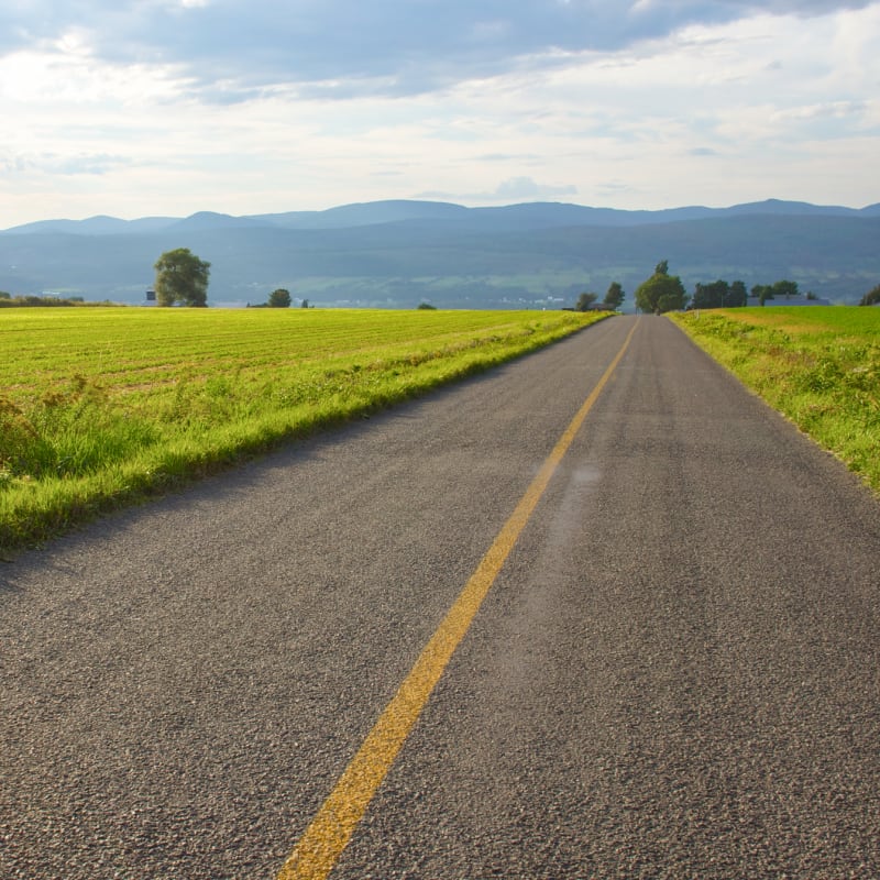 A scenic road cutting through the fields of Île d’Orléans