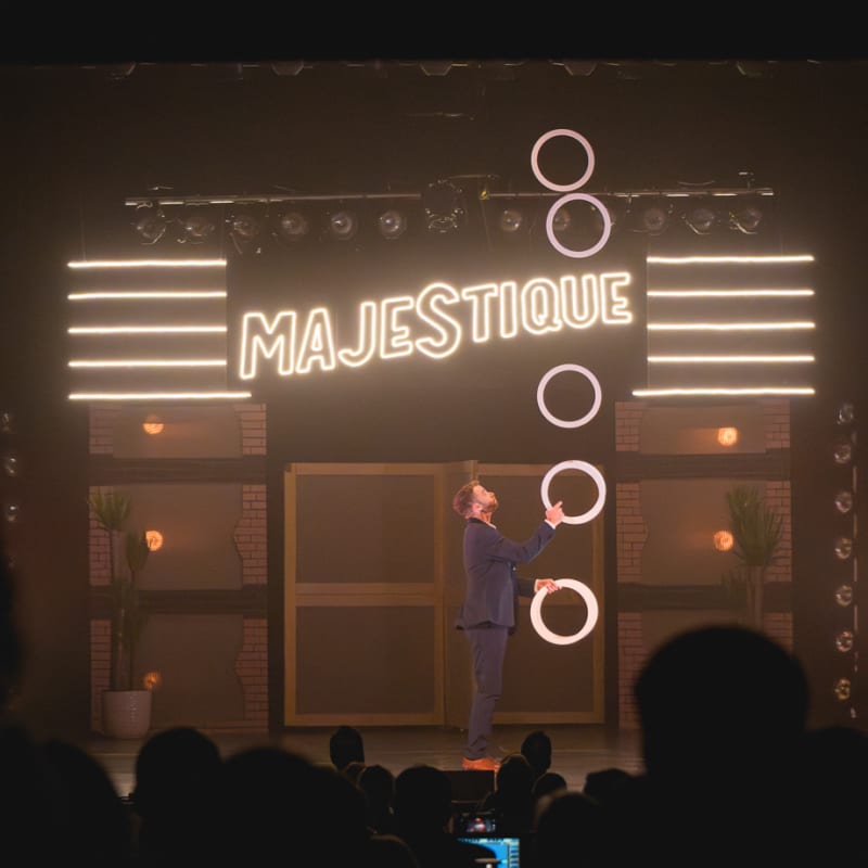Théâtre Place Majestique a juggler is performing with small hoops on stage