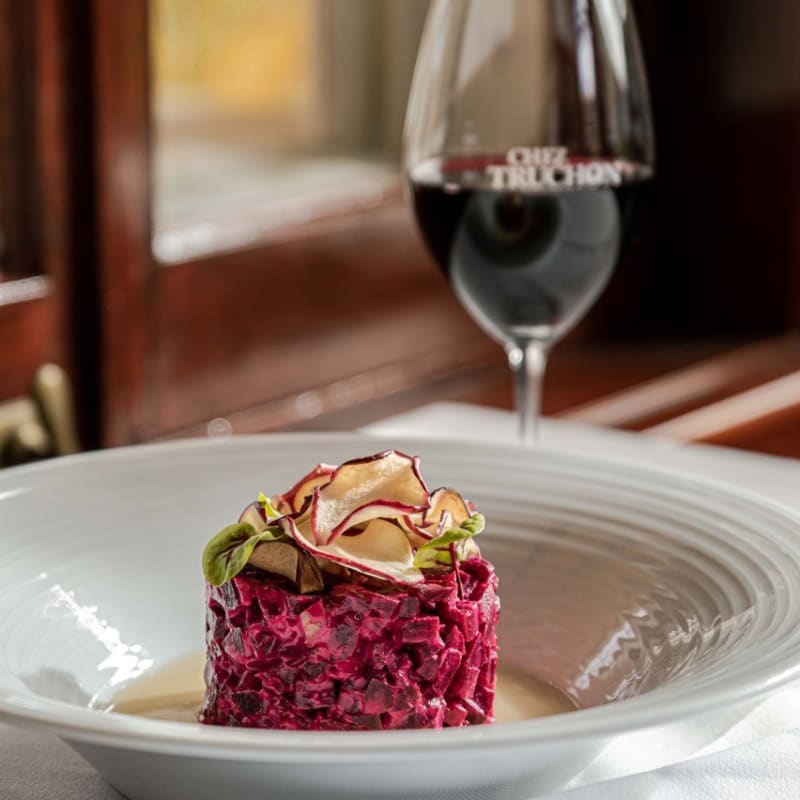 Assiette et verre de vin rouge au restaurant Chez Truchon