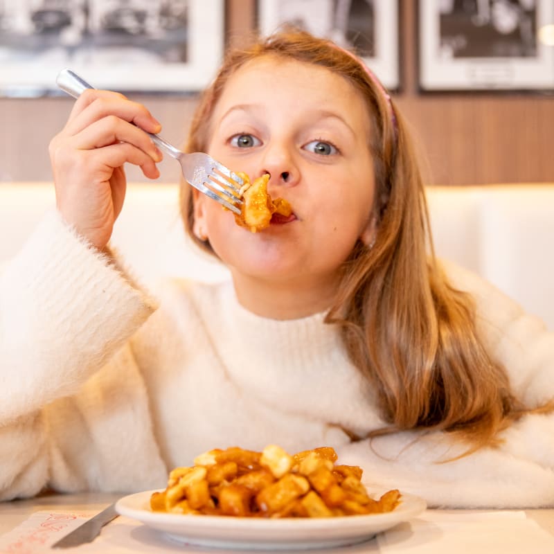 Tourisme Drummondville young girl enjoying a delicious poutine