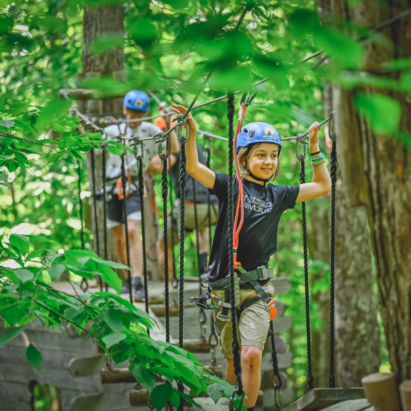 Kids in a treetop obstacle course at Arbraska Duchesnay.