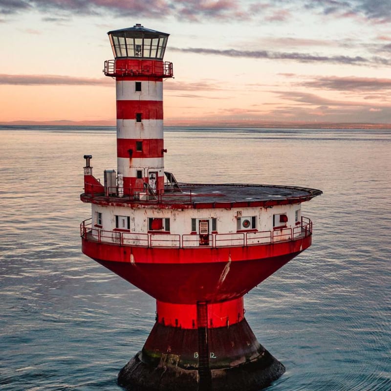 Lighthouse station in the middle of a body of water.