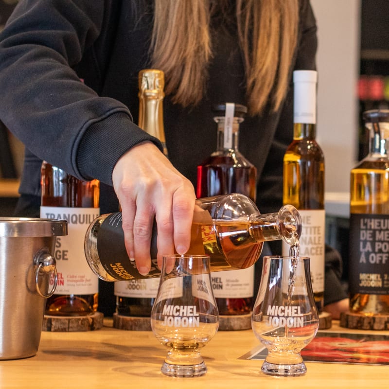 Femme qui prépare une dégustation de cidres.