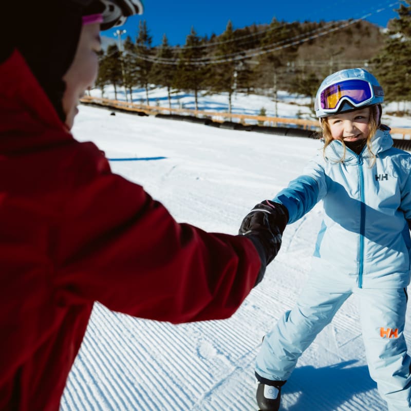 Girl on skis and an instructor.