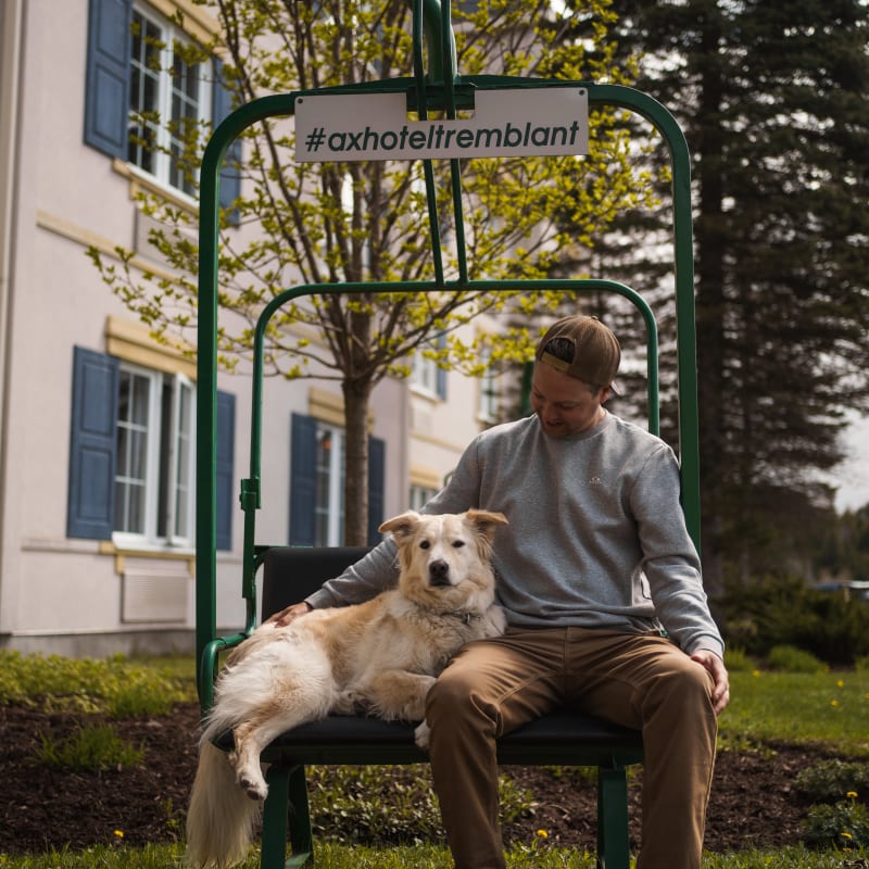 Man and dog outside Ax Hôtel Mont-Tremblant.
