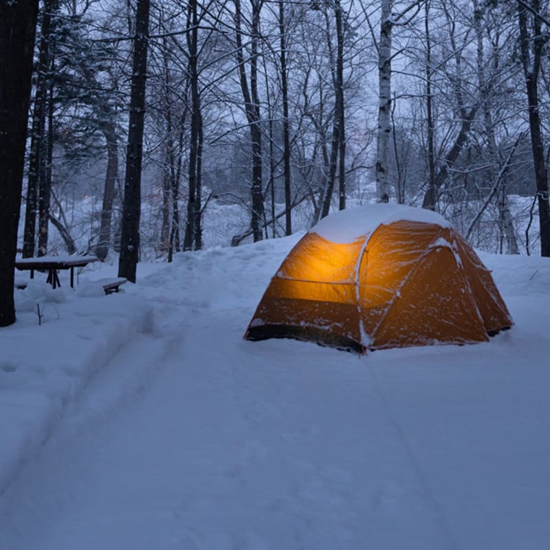 Lighted camping tent on snow