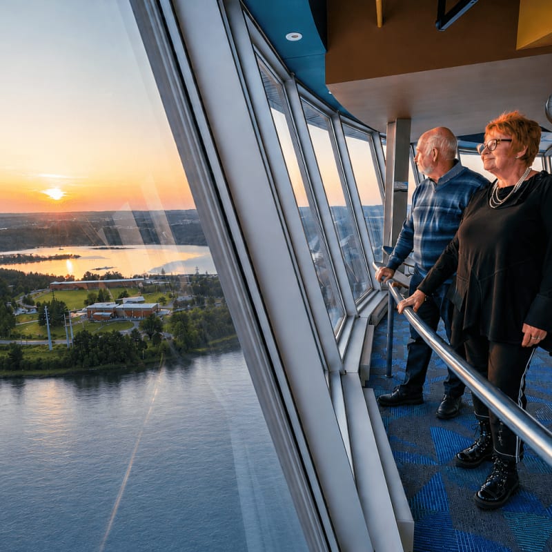 Au coucher de soleil, un couple admire la vue au sommet de la tour d’observation Hydro-Québec à La Cité de l'énergie.