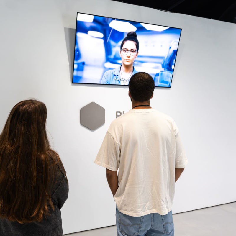 deux personnes en train de regarder une vidéo explicative durant l'Expérience Black Mirror.