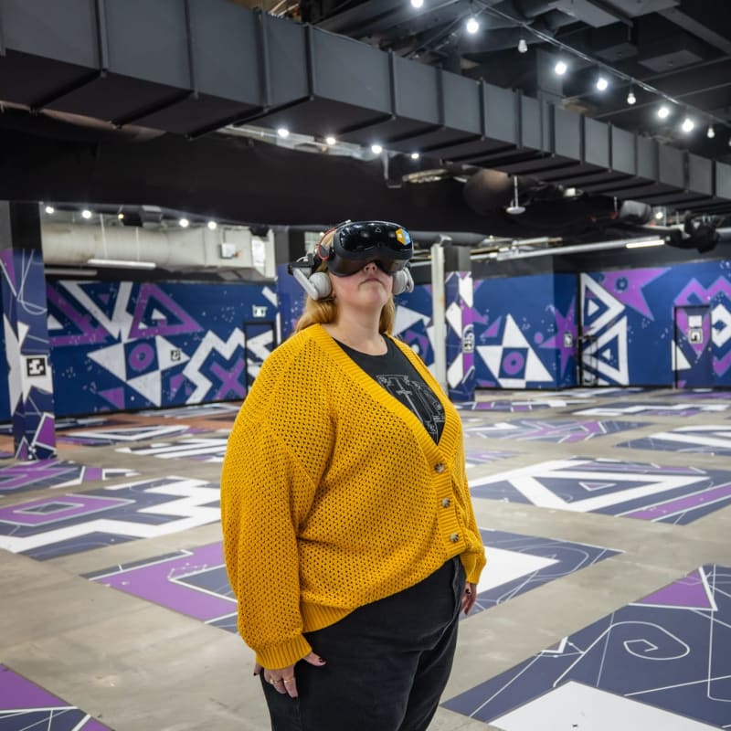 Femme avec un casque de réalité virtuelle qui regarde vers le haut.