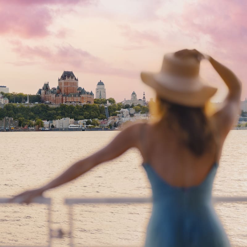 Femme qui regarde le Château Frontenac à partir du fleuve.