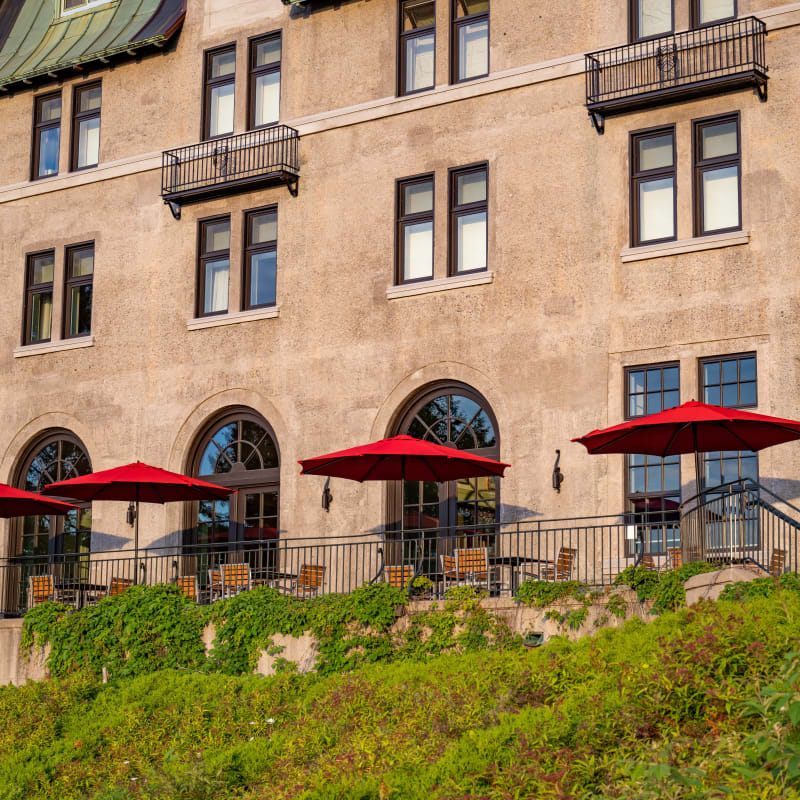 Terrace with several red umbrellas at the Fairmont Le Manoir Richelieu.