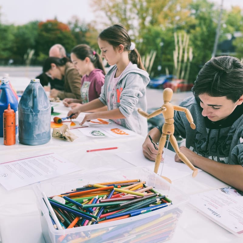 Enfants faisant des dessins à l'extérieur.