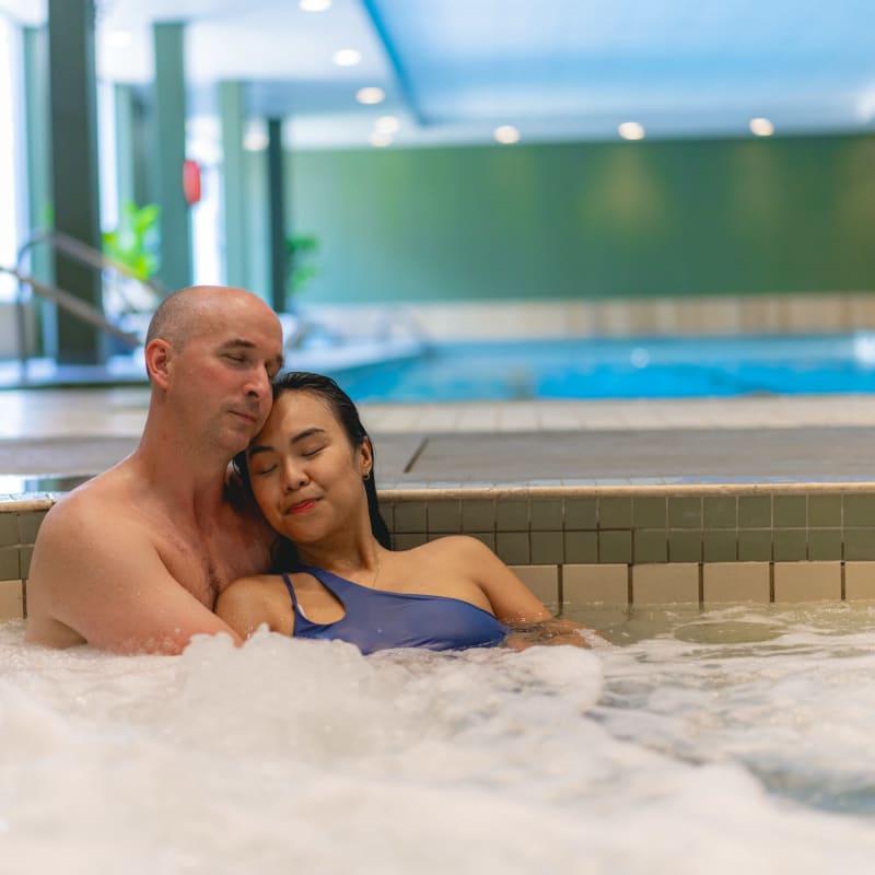 A couple entwined in a hot tub.