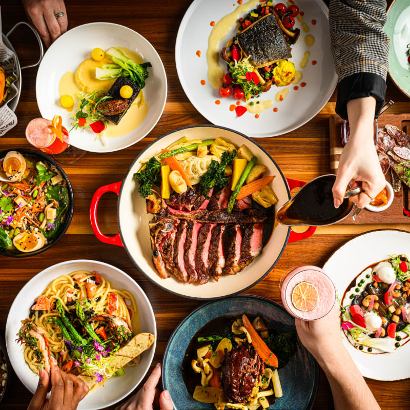 Large table filled with a variety of colorful, gourmet dishes, seen from above.