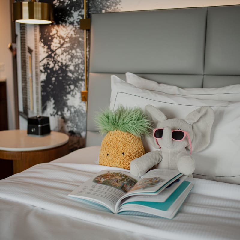 Stuffed animals on a hotel bed at the Hilton Québec, alongside a children’s book.