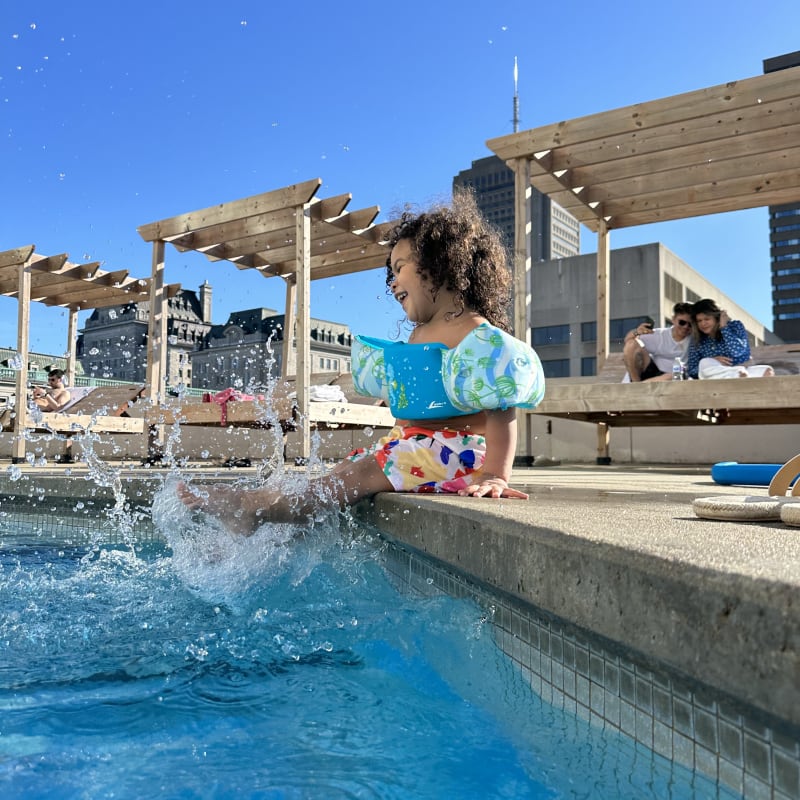 Little girl by the rooftop outdoor pool at Hilton Québec.