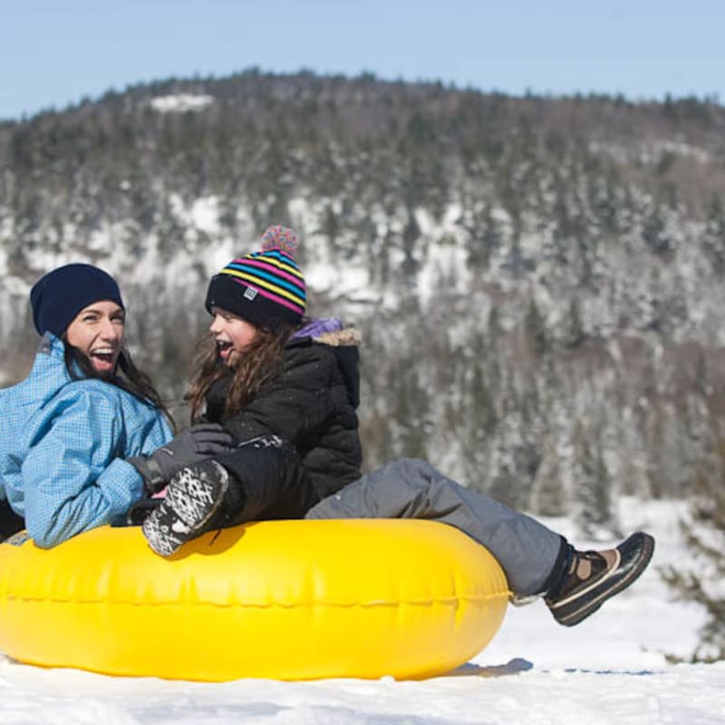 Mère et enfant en glissade sur tube.