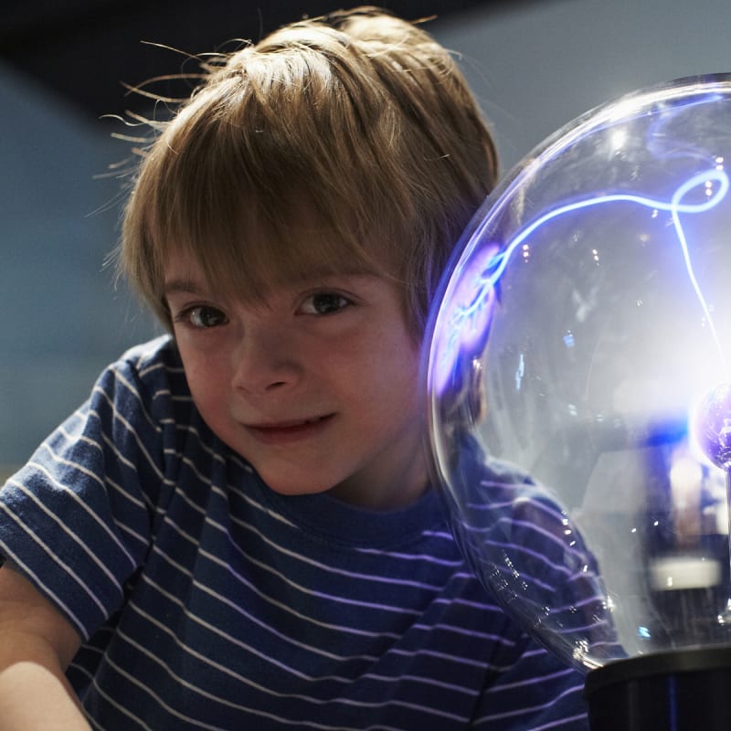 Kid next to a Van de Graaff.