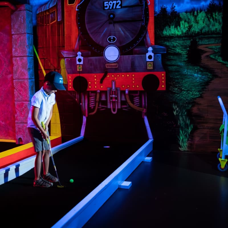 Children are playing a game of mini-golf at Laser Force Drummondville