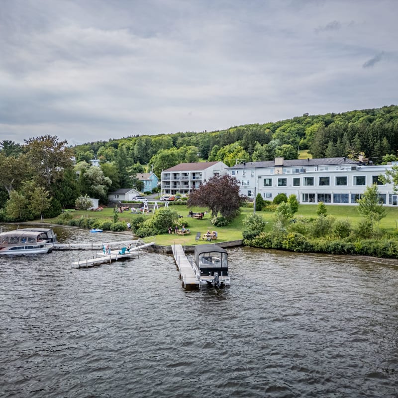 Lac Etchemin et le manoir installé sur ses rives, avec trois quais et des embarcations.