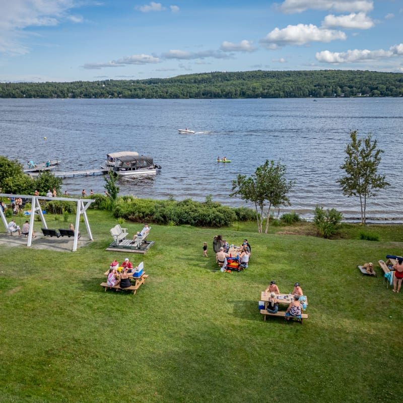 Groupes de personnes assises au bord de l'eau au Manoir Lac-Etchemin.