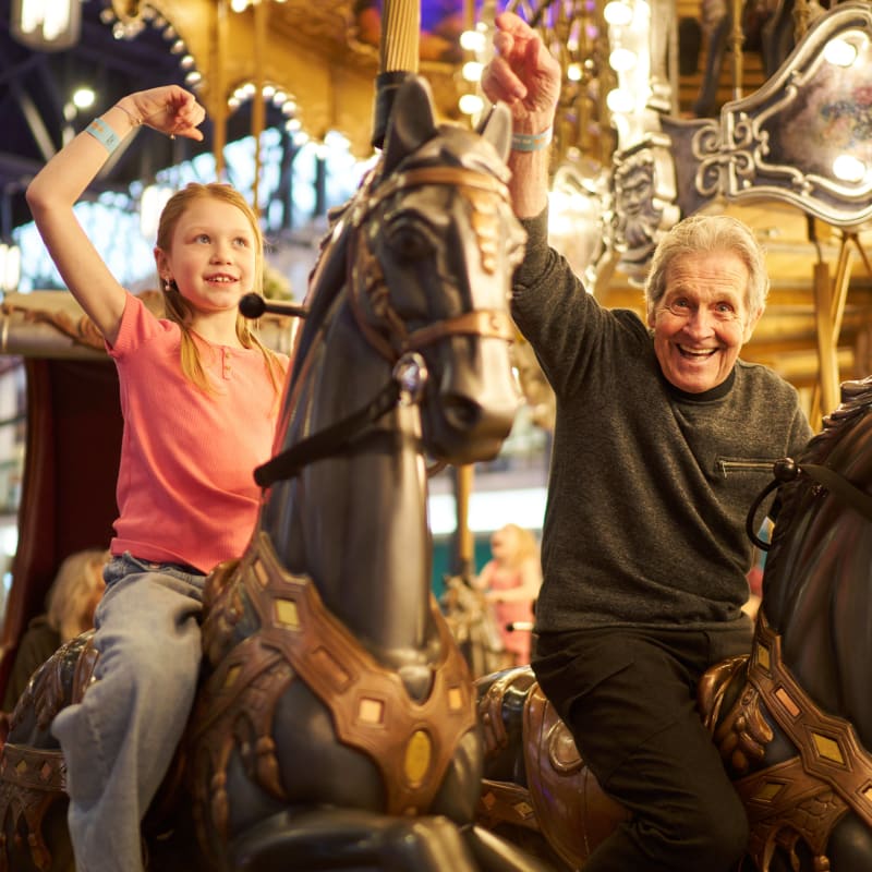 Fillette et homme dans un carrousel.