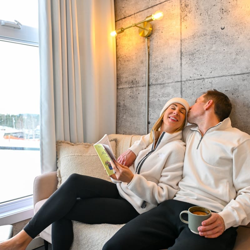 Smiling couple inside a Coolbox accommodation at Mont Grand-Fonds.