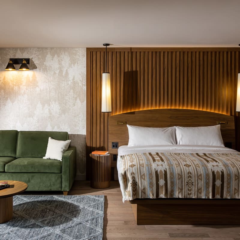 Grande chambre à l'Hôtel-Musée Premières Nations, avec lit et divan.