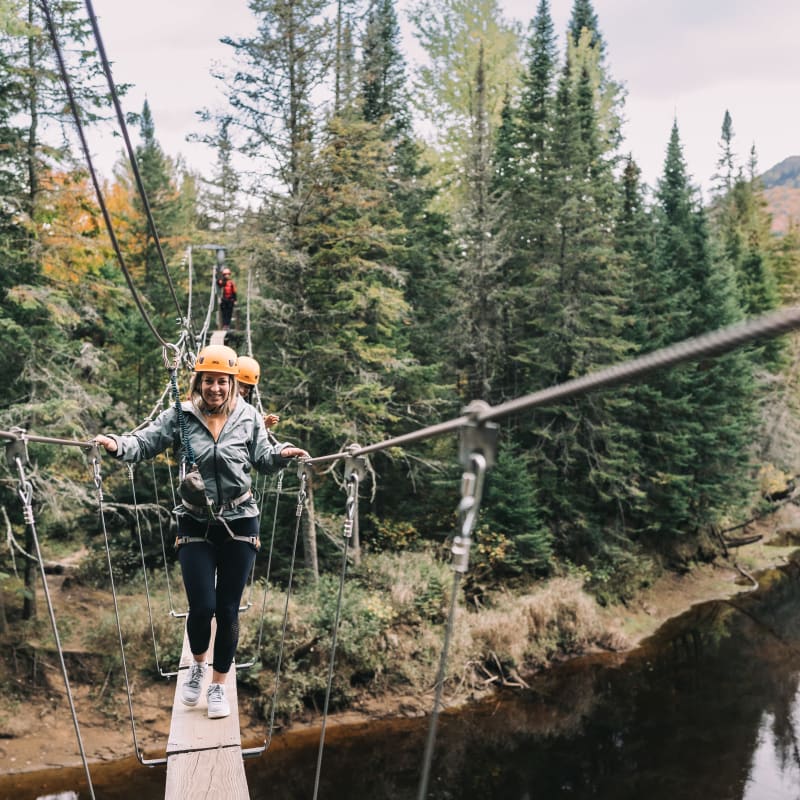 Woman on a suspended footbridge at parc national du Mont-Tremblant.
