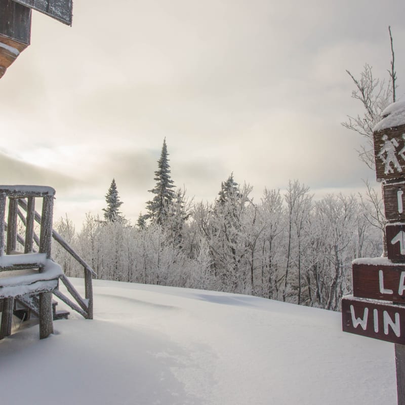 Signalisation vers le lac Windigo à côté d'un chalet en bois rond au parc régional Montagne du Diable.