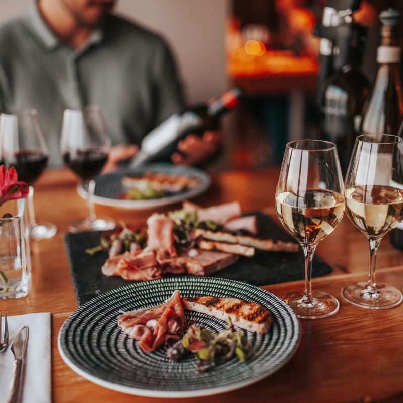 Tasting experience with multiple glasses of wine and a plate of food.