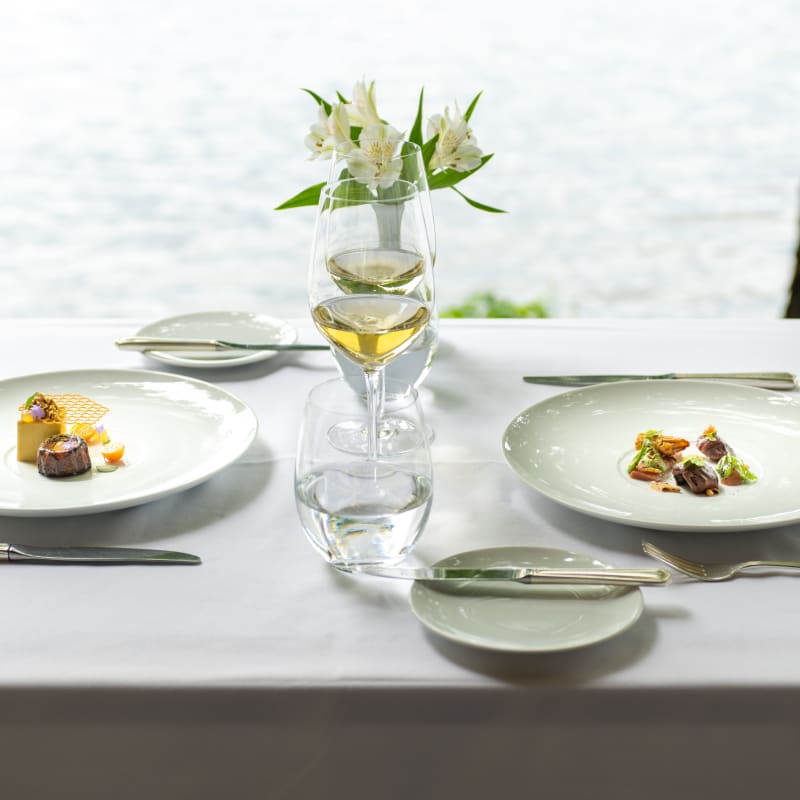 Table au bord de l'eau avec deux assiettes l'été au Ripplecove.