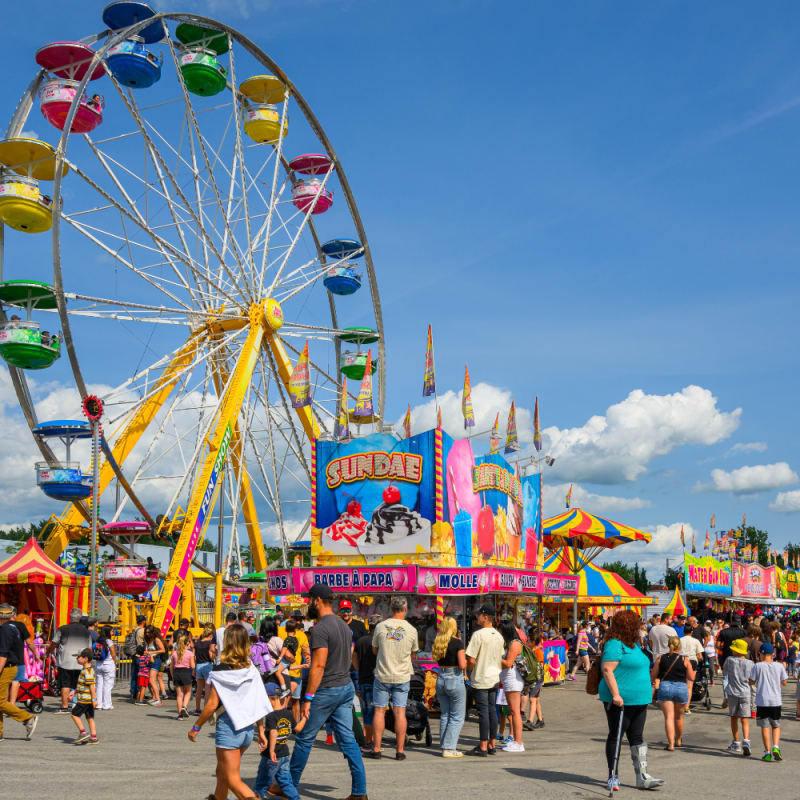 Manèges et kiosques colorés avec une foule de personne à l'Expo agricole de Saint-Hyacinthe.