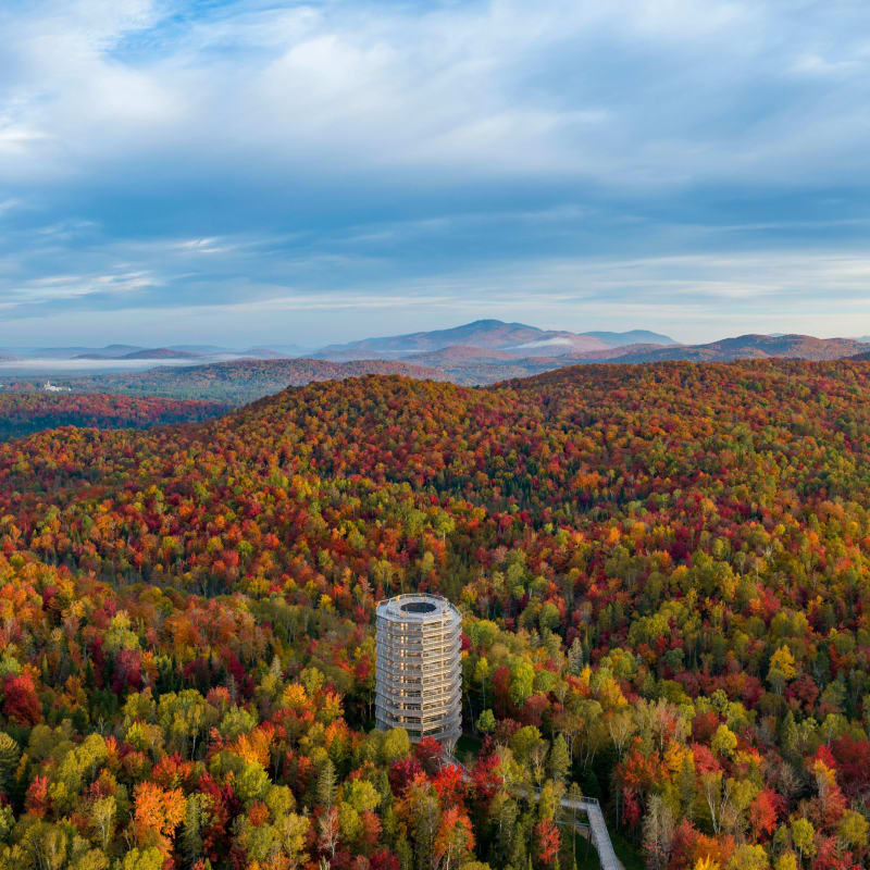 Vue aérienne de la tour panoramique du Sentier des cimes, entouré de montagnes colorées.