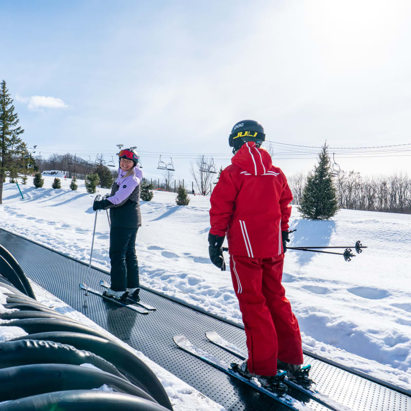 Young woman on the ski lift with her instructor.