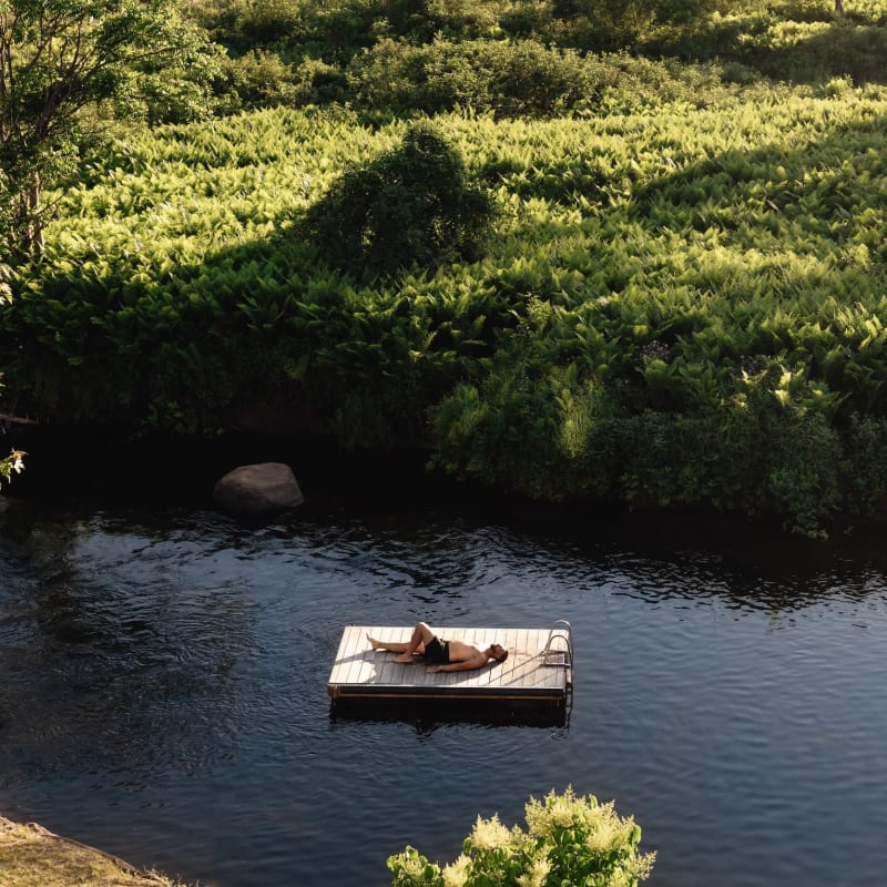 Homme étendu sur un quai dans un plan d'eau.