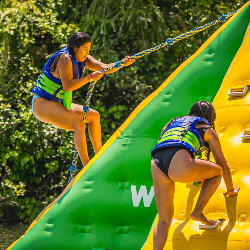 People climbing a spectacular floating inflatable structure at the Super Aqua Club