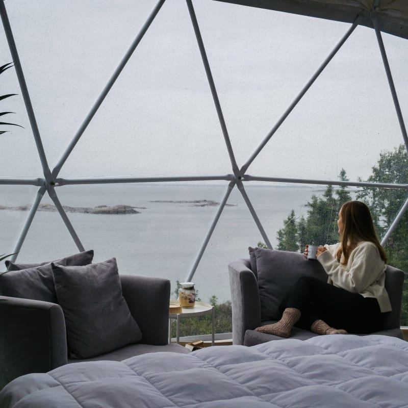 Woman in a unit shaped like a bubble at En Forêt in Côte-Nord.