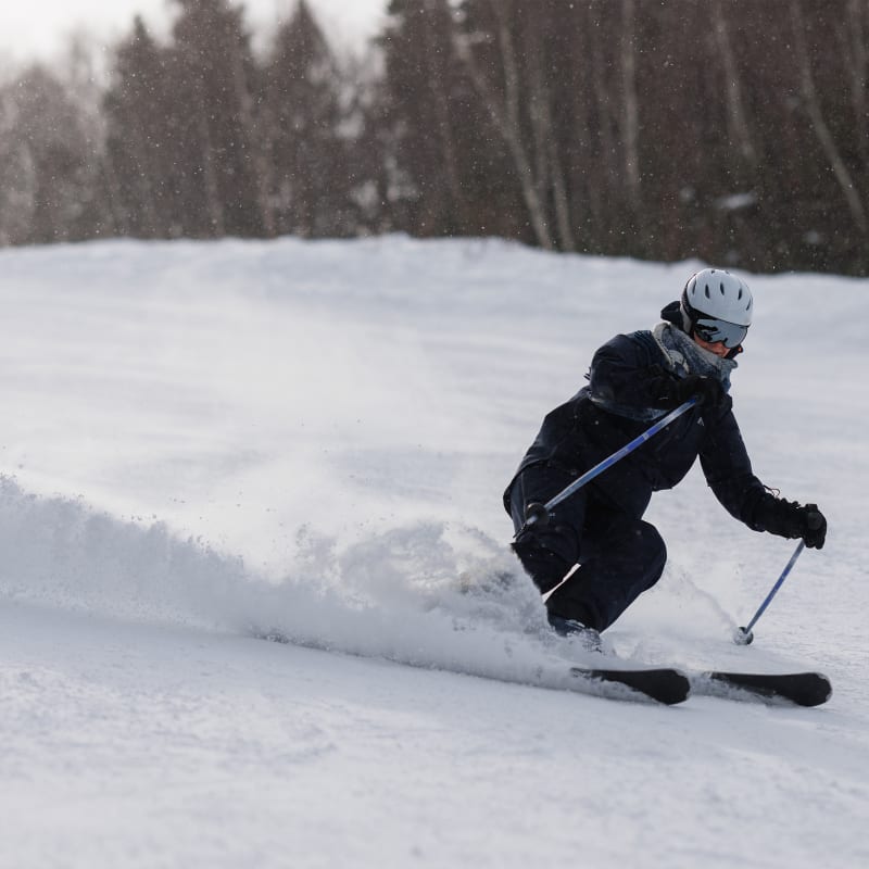 Person skiing downhill on an ski slope.