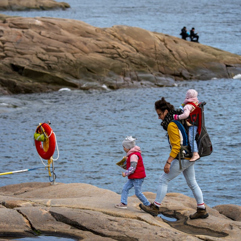 Mère et deux enfants en randonnée sur le bord de la mer.