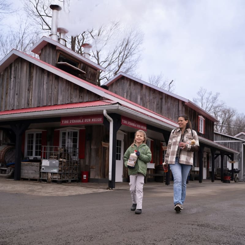 Woman and girl bringing back maple products, Sucrerie Constantin.
