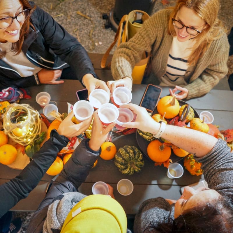 Group of women around a table decorated with pumpkins.