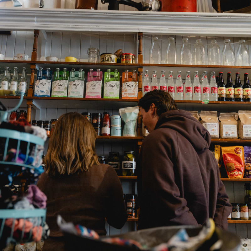 Couple au comptoir du café et bel étalage d'antan.