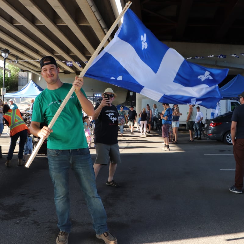 Homme brandissant le drapeau du Québec à la St-Jean-Baptiste - Sainte-Anne-de-Bellevue.