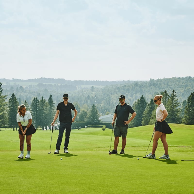 Quatre personnes sur un vert au Club de golf de Milby.